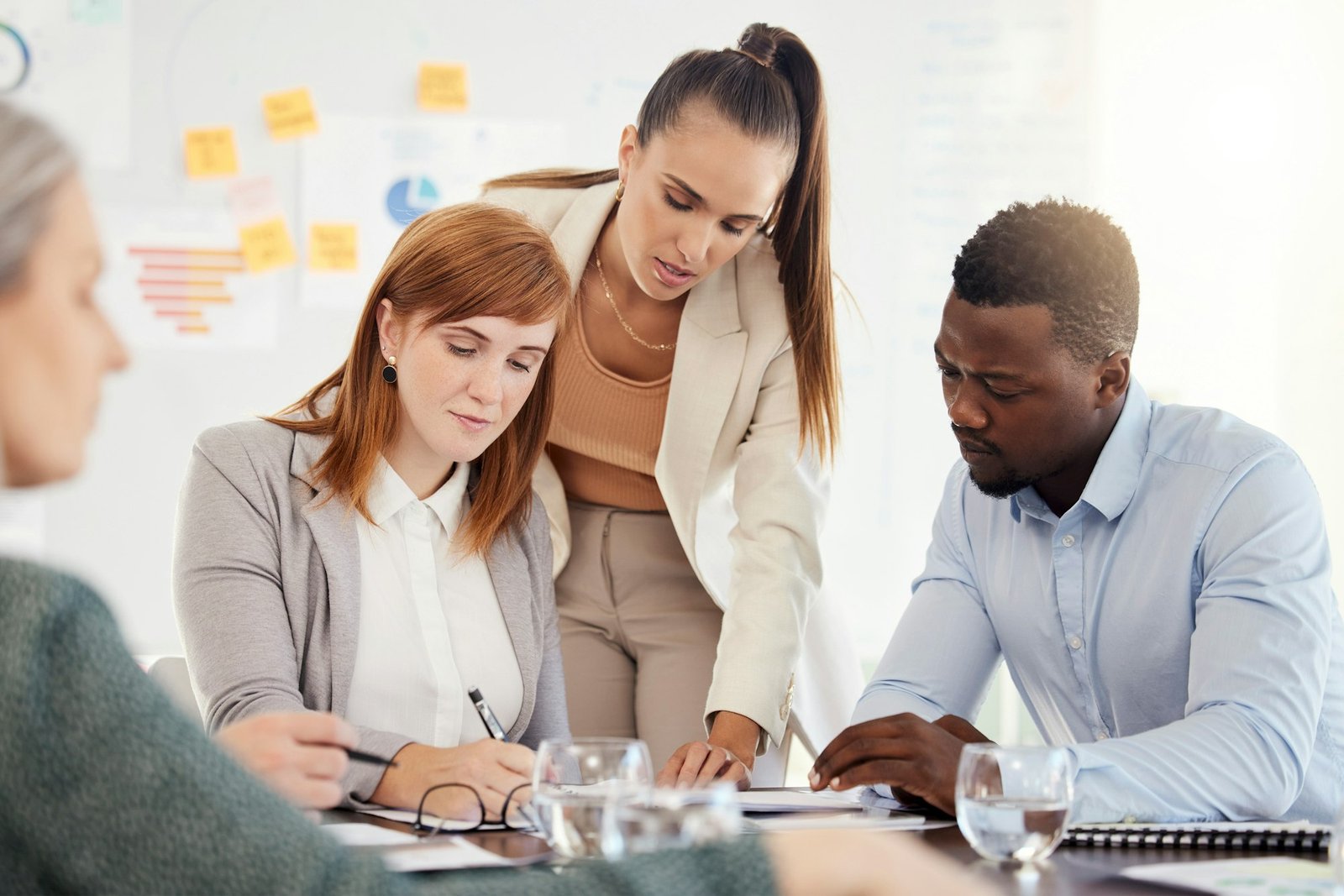 Business people, financial and meeting at a table with serious workers planning, writing and prepar