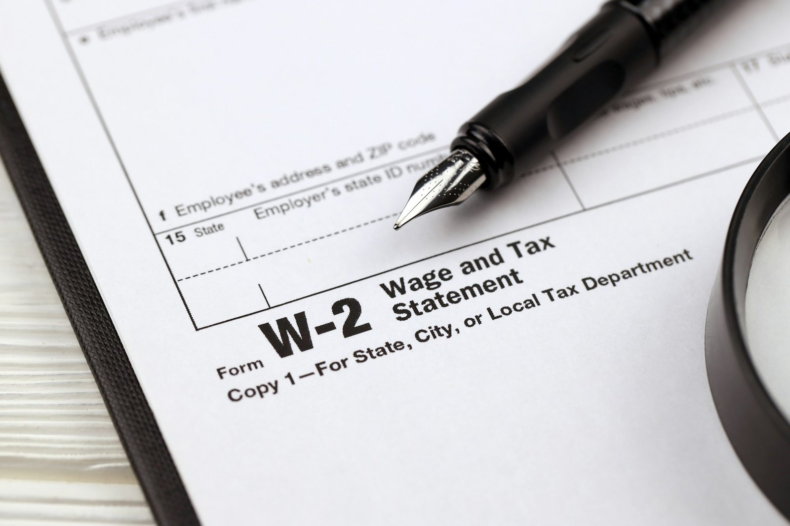 IRS Form W-2 Wage and Tax Statement blank on A4 tablet lies on office table with pen